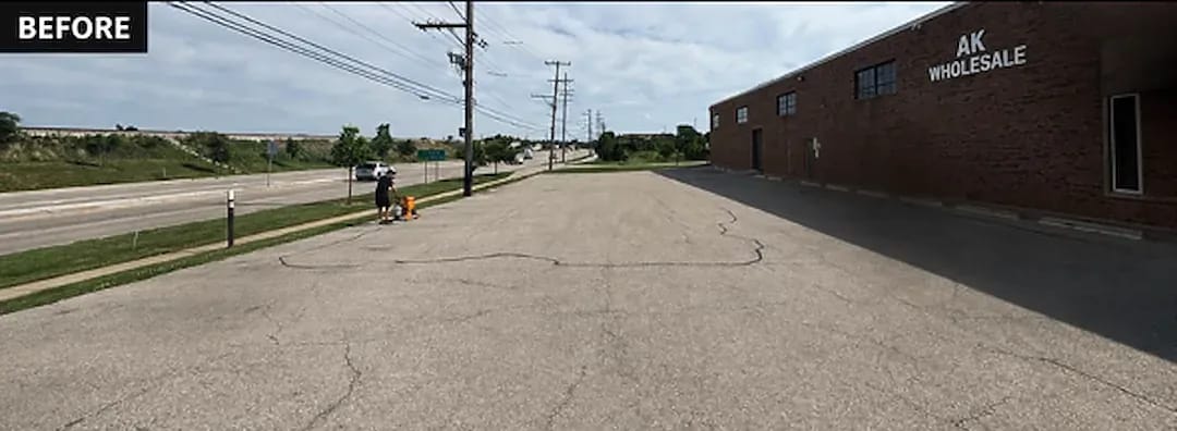 Cracked, faded asphalt parking lot with no visible stall markings before treatment